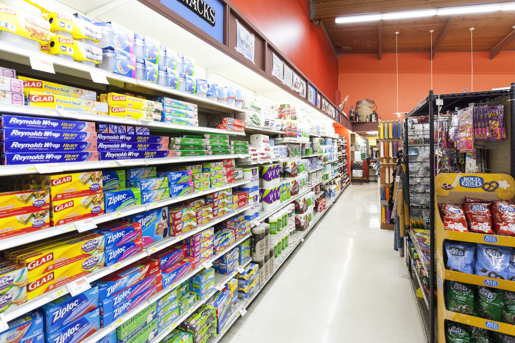 A retail aisle densely stocked with packaged household products.